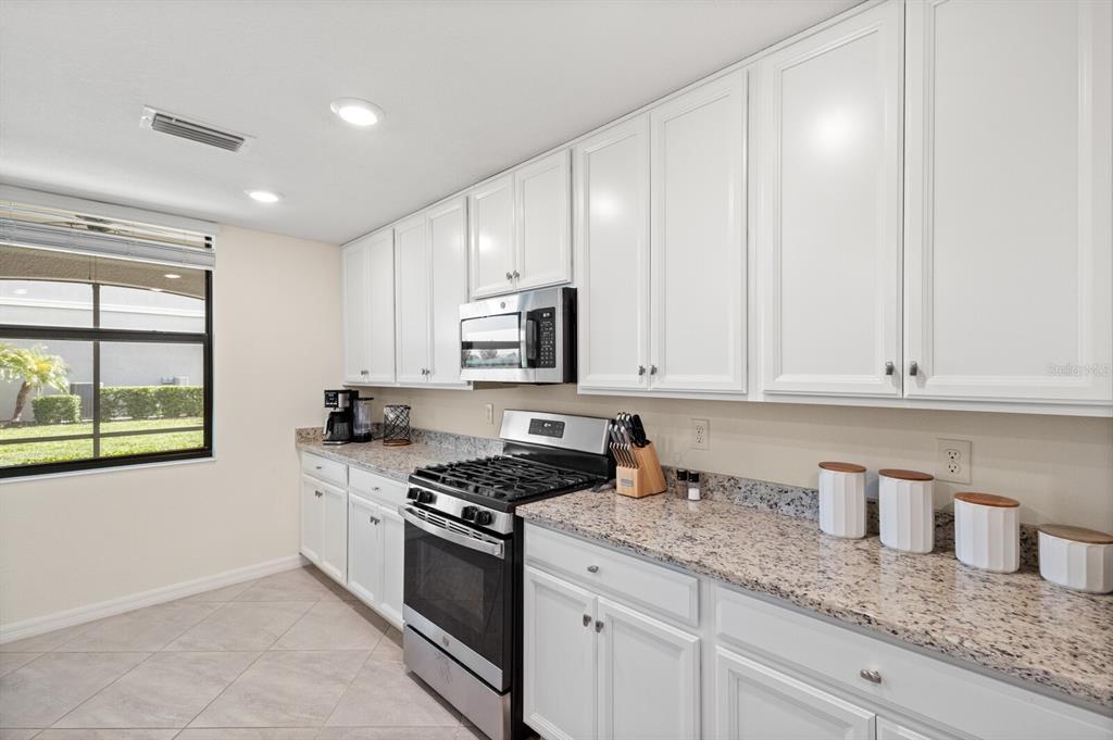 18117 Gawthrop Drive, Unit 104 Bradenton, FL 34211 - Photo 12 of 54 a kitchen with granite countertop white cabinets and stainless steel appliances
