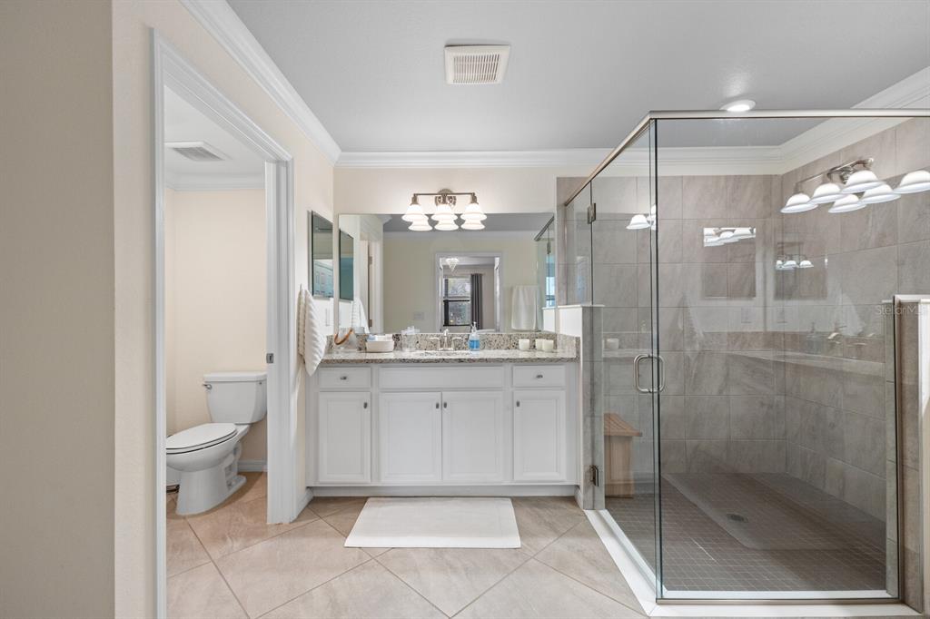 18117 Gawthrop Drive, Unit 104 Bradenton, FL 34211 - Photo 18 of 54 a bathroom with a toilet a sink a mirror and a shower