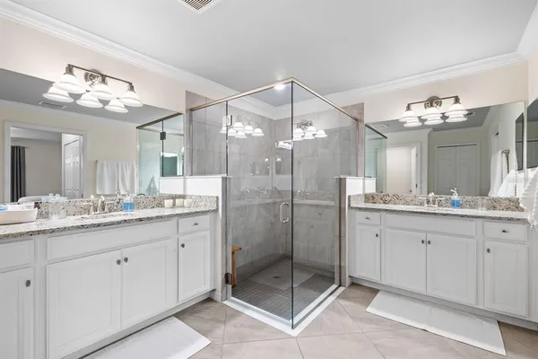 a bathroom with a granite countertop sink a mirror and a shower