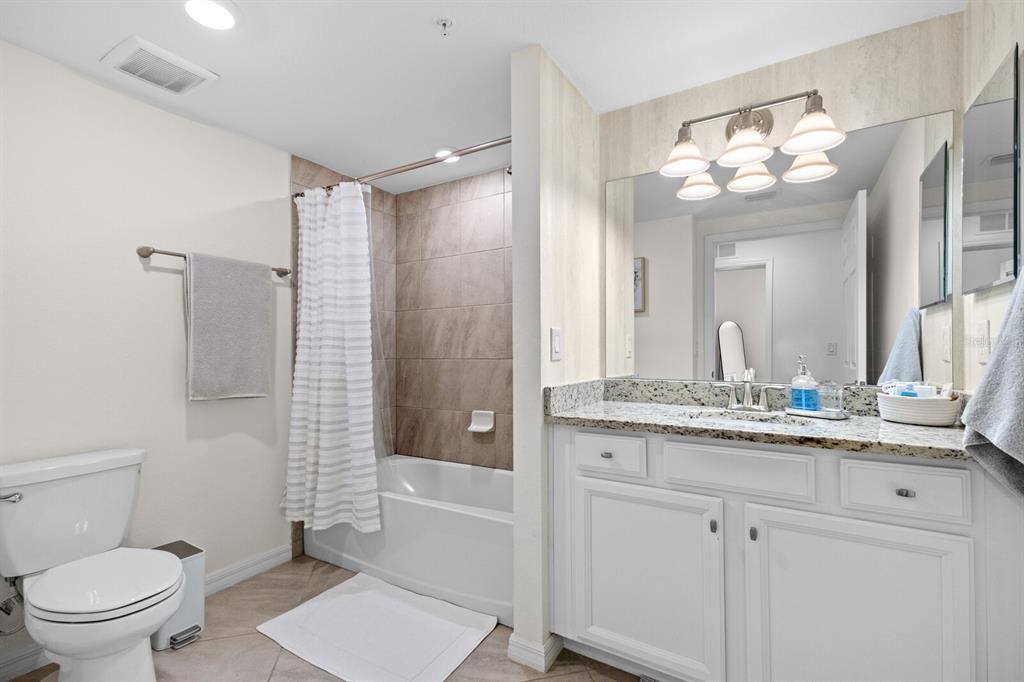 18117 Gawthrop Drive, Unit 104 Bradenton, FL 34211 - Photo 20 of 54 a bathroom with a granite countertop sink a toilet a mirror a vanity and shower