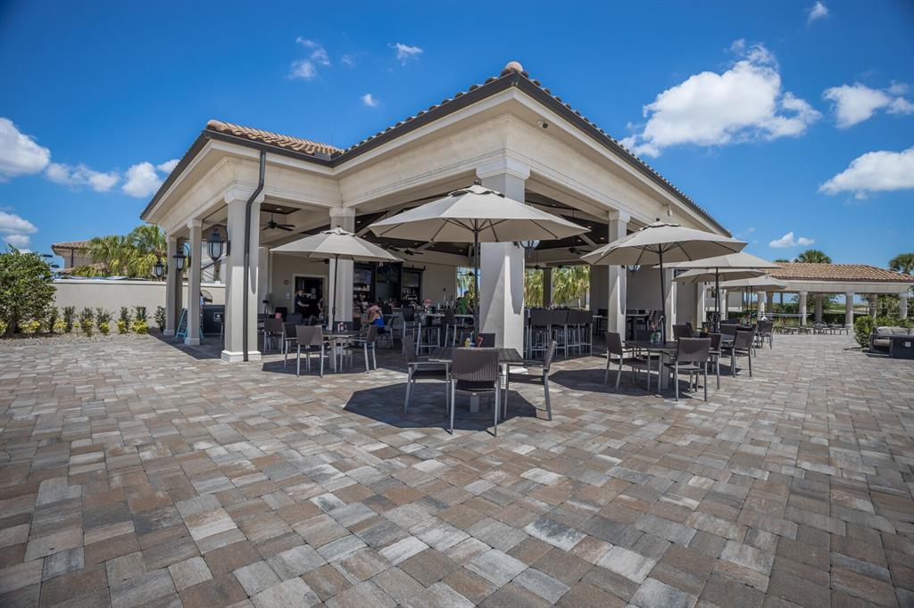 18117 Gawthrop Drive, Unit 104 Bradenton, FL 34211 - Photo 53 of 54 a view of a patio with a table and chairs under an umbrella