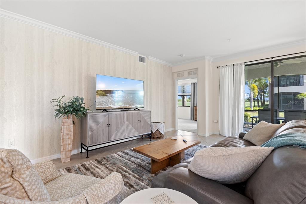 18117 Gawthrop Drive, Unit 104 Bradenton, FL 34211 - Photo 8 of 54 a living room with furniture and a flat screen tv