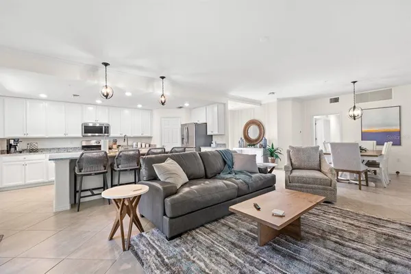 a living room with furniture and view of kitchen