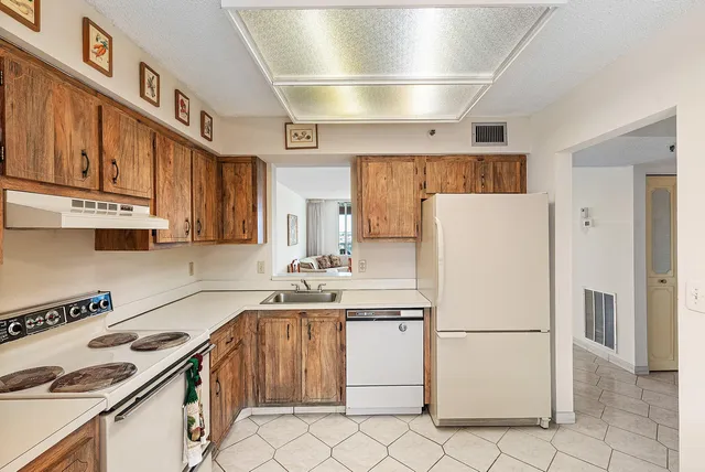 a kitchen with a sink a refrigerator and cabinets