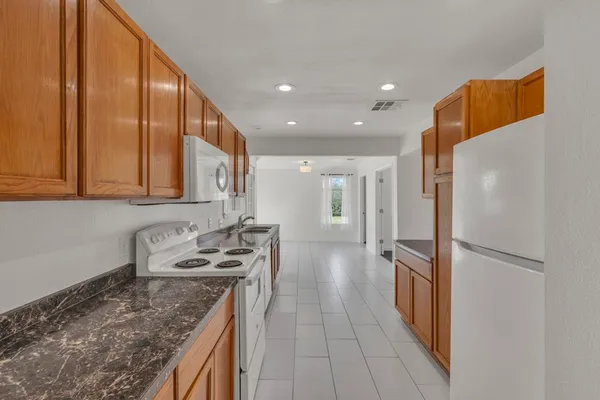 a kitchen with stainless steel appliances granite countertop a refrigerator and a stove