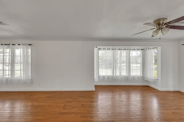 a front view of a house with a garden and trees