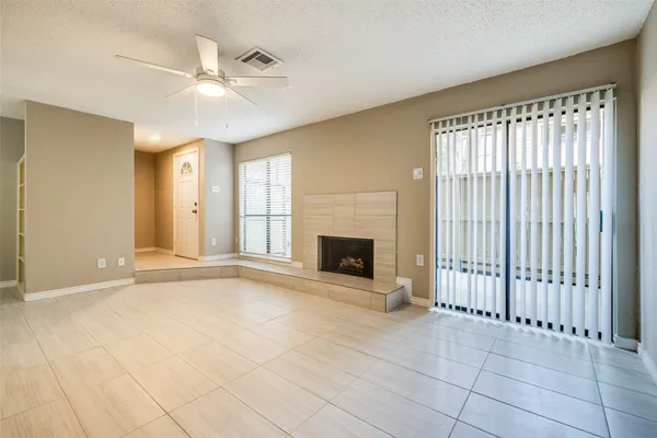 a view of an empty room with a fireplace and a window