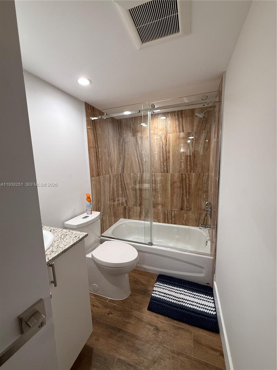 995 Southwest 84th Avenue, Unit 304 Miami, FL 33144 - Photo 11 of 15 a bathroom with a sink a toilet a mirror and shower