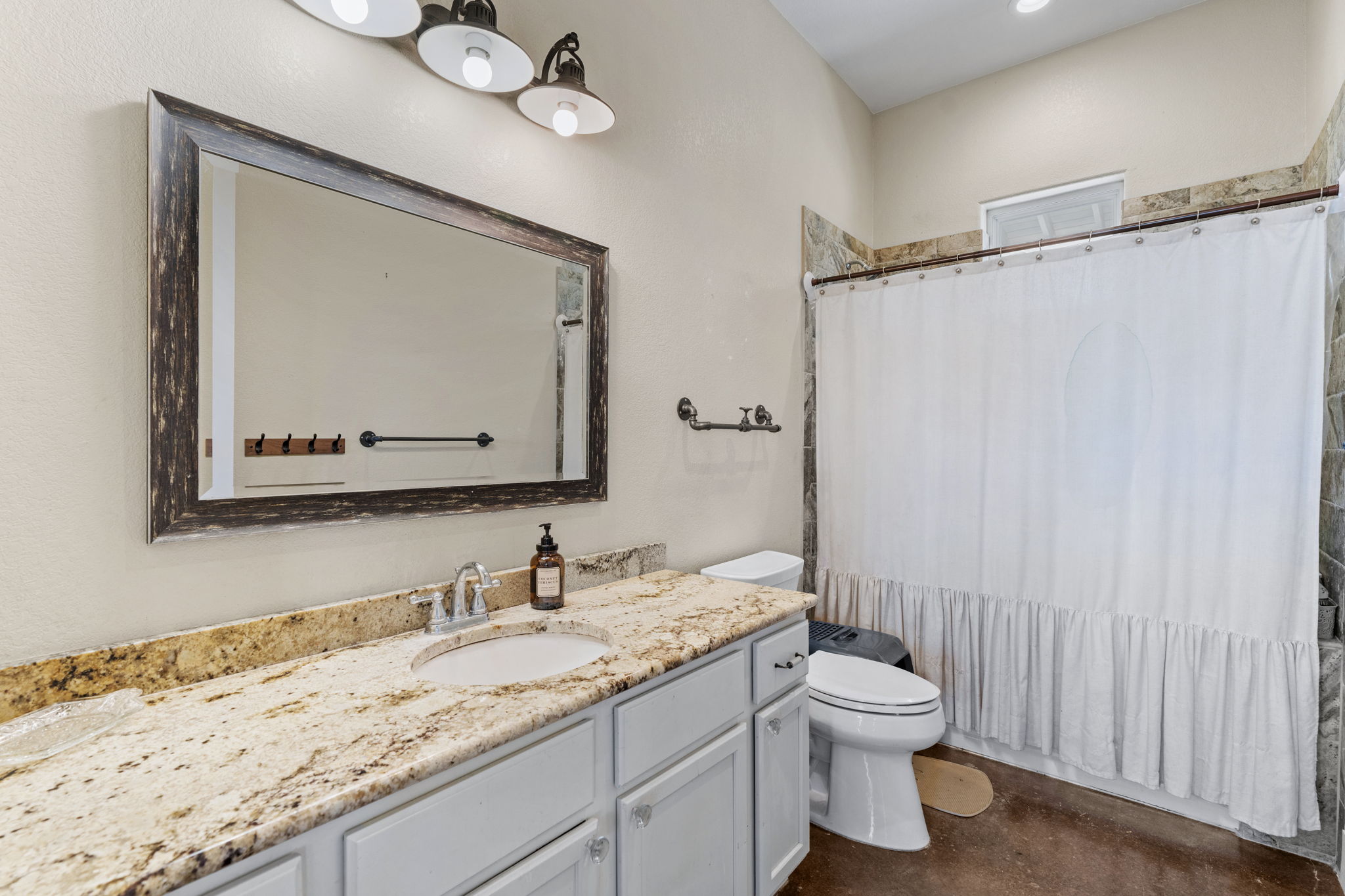 6350 Mt Sharp Road, Unit B Wimberley, TX 78676 - Photo 15 of 34 a bathroom with a granite countertop sink toilet and shower