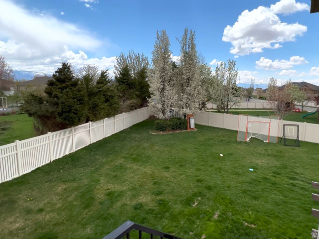36 North Trailside Road West Farmington, UT 84025 - Photo 15 of 15 Expansive backyard featuring a lush green lawn, full privacy fencing, mature trees, and landscaping