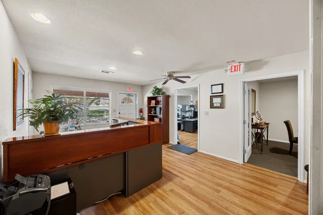 a living room with furniture a flat screen tv and kitchen view