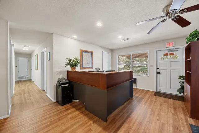 a kitchen with granite countertop a refrigerator a stove a sink dishwasher and a dining table with wooden floor