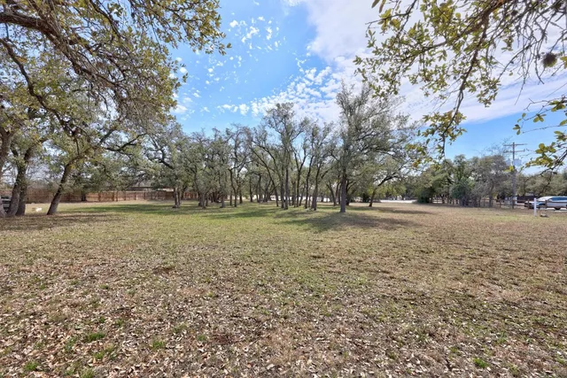 a view of dirt field with trees