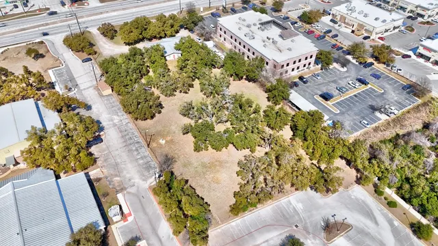 an aerial view of a house with a yard and wooden fence