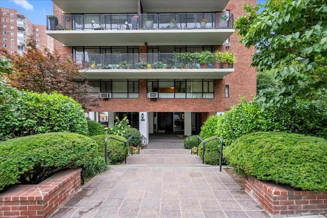 a view of brick house with large windows and a table and chairs