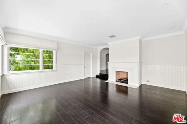 an empty room with wooden floor and a window
