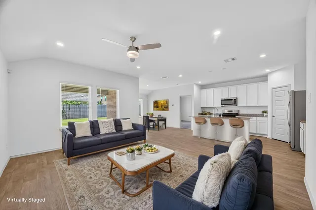 a living room with furniture kitchen view and a window