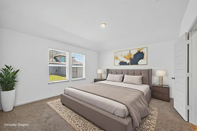 a bedroom with a bed a potted plant and a window