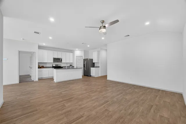 a view of kitchen with kitchen island white cabinets and stainless steel appliances