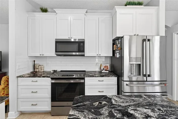 a kitchen with stainless steel appliances granite countertop a sink stove and cabinets