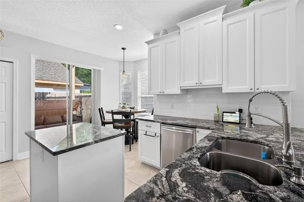 a kitchen with kitchen island granite countertop a sink appliances cabinets and a counter top space