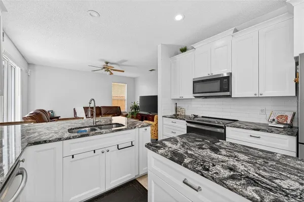 a kitchen with stainless steel appliances granite countertop white cabinets and a granite counter tops