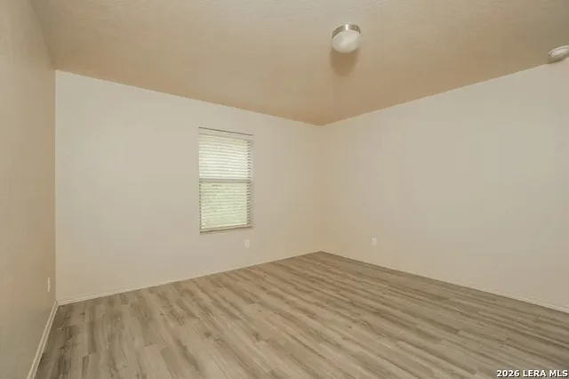 a view of a room with wooden floor and window