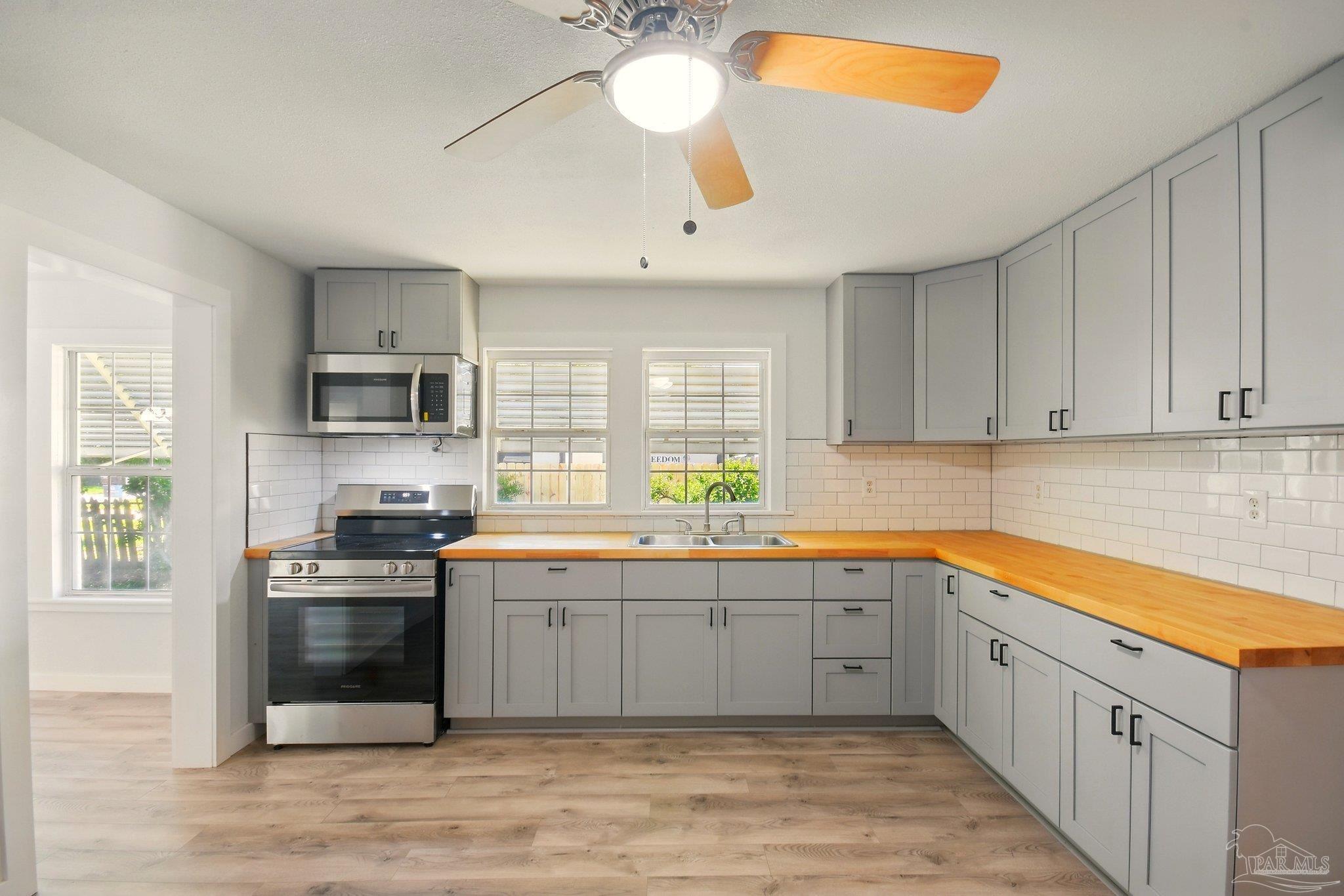 4329 Floridatown Road Pace, FL 32571 - Photo 10 of 32 a kitchen with stainless steel appliances a sink stove and cabinets