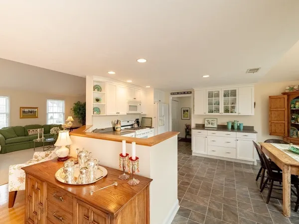 a kitchen with granite countertop white cabinets and white appliances