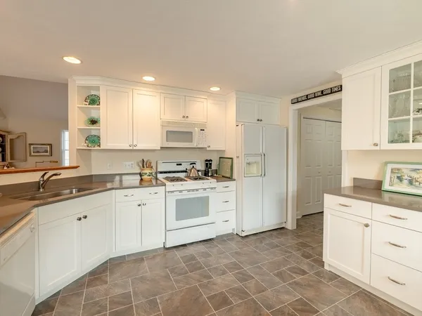 a open dining room with stainless steel appliances a table and chairs