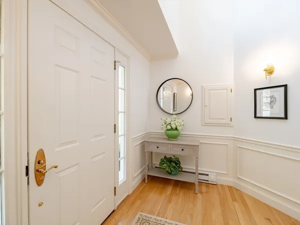 a view of hallway with window and wooden floor