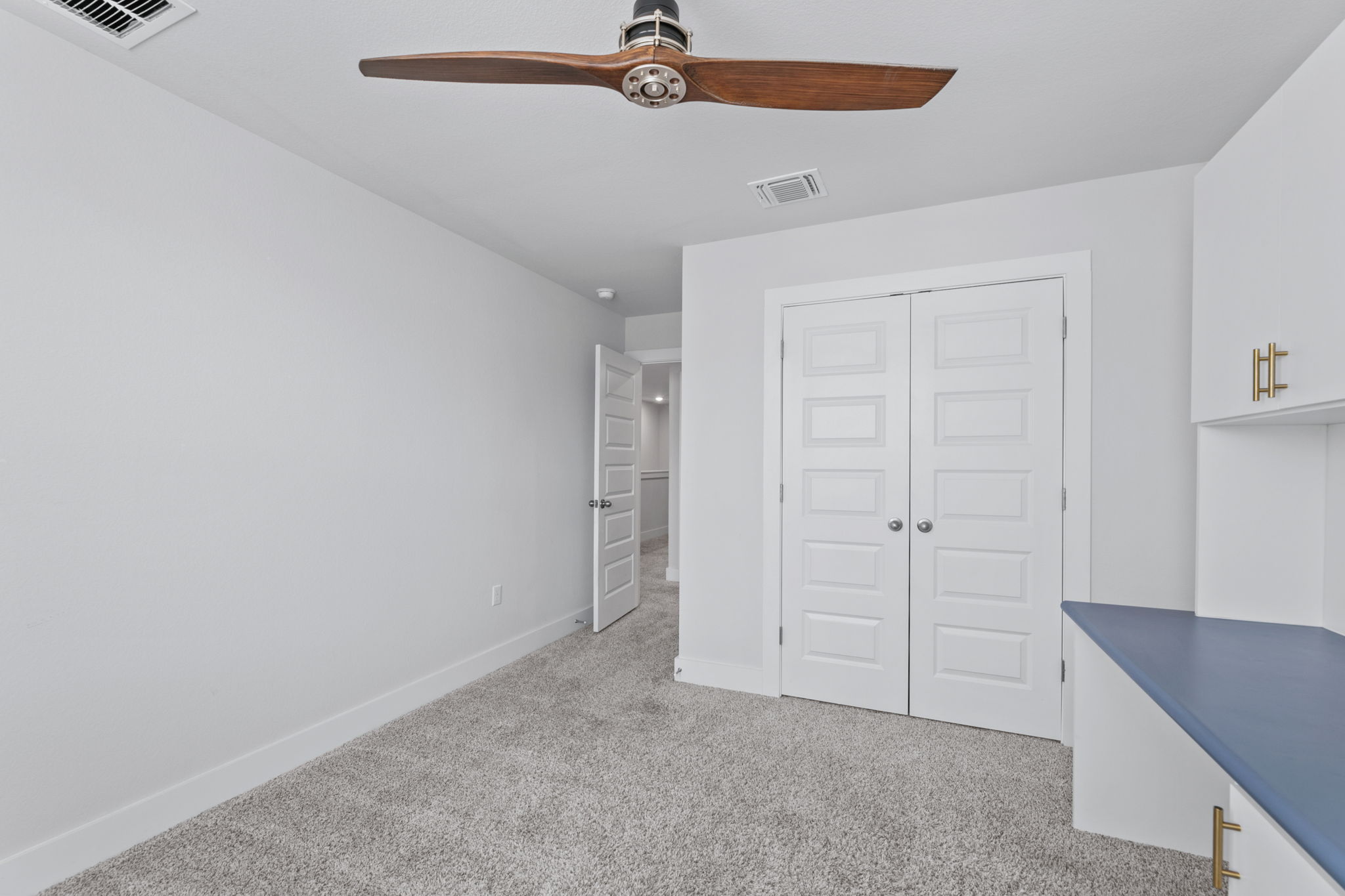 7312 Travertine Spring Drive Austin, TX 78744 - Photo 27 of 32 A quiet bedroom featuring plush carpet and a stylish ceiling fan, perfect for relaxation or study.