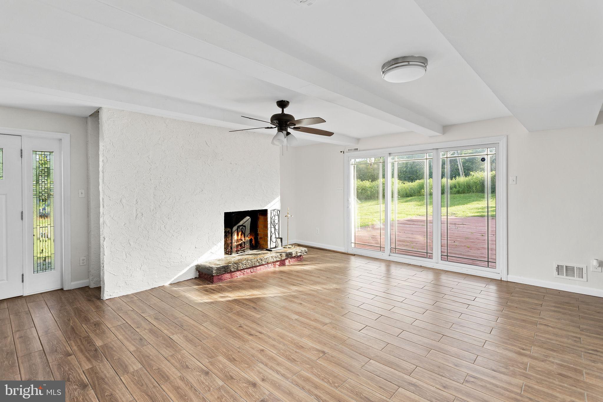 2264 Pennington Road Trenton, NJ 08638 - Photo 5 of 24 a view of an empty room with a window and wooden floor