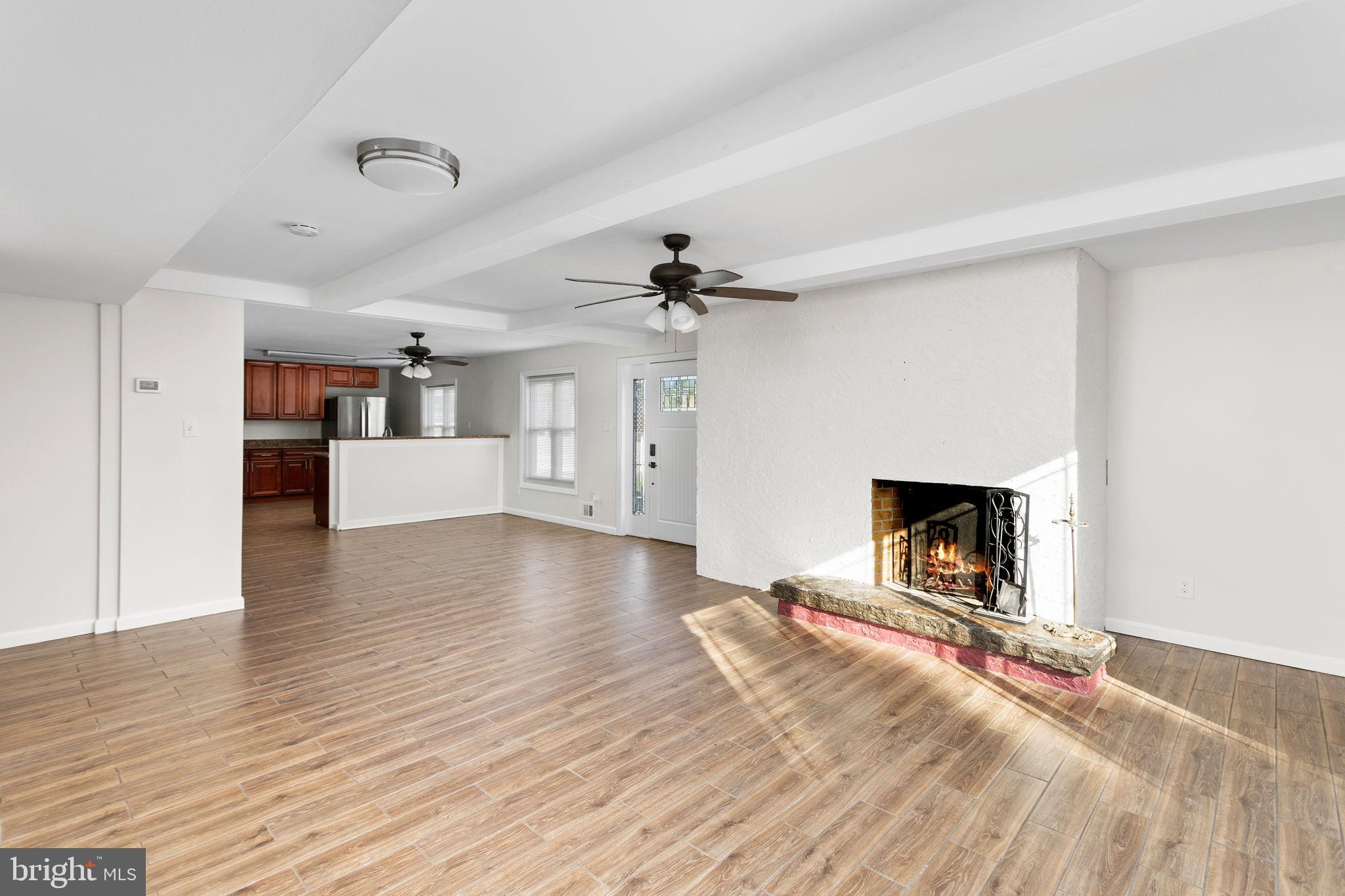 2264 Pennington Road Trenton, NJ 08638 - Photo 6 of 24 a view of a livingroom with a fireplace a chandelier and wooden floor