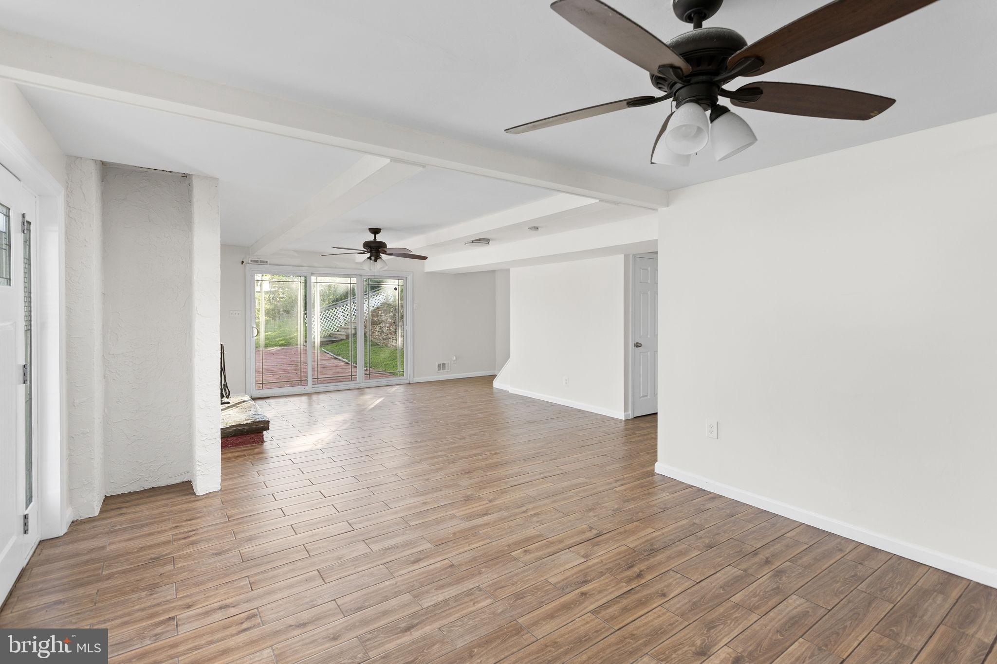 2264 Pennington Road Trenton, NJ 08638 - Photo 8 of 24 an empty room with wooden floor chandelier fan and windows