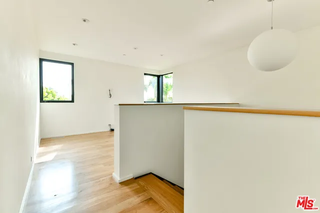 a view of a room with a wooden floor and white walls