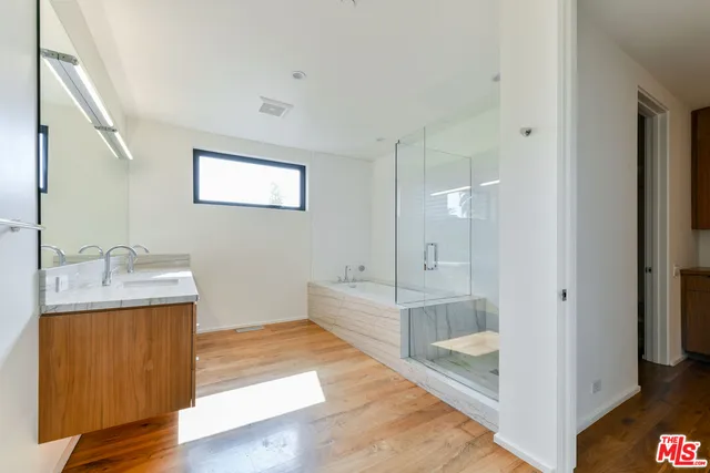 a bathroom with a double vanity sink and mirror with shower