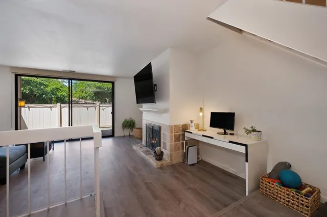 a living room with furniture a flat screen tv and a fireplace