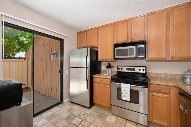 a kitchen with stainless steel appliances granite countertop a sink and a stove