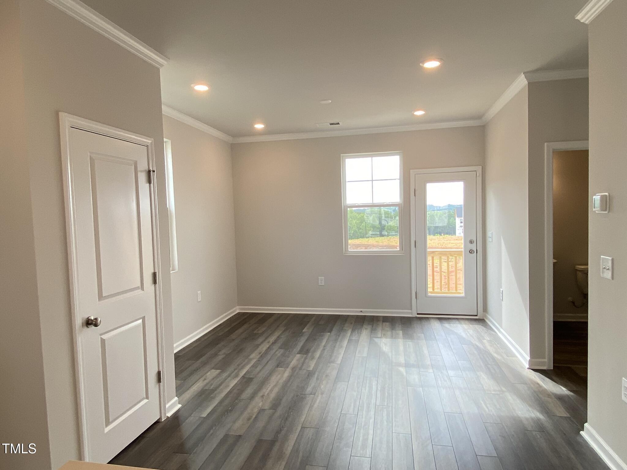 722 Gimari Drive Wake Forest, NC 27587 - Photo 12 of 25 an empty room with wooden floor and windows