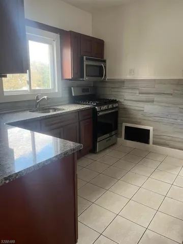 a metallic refrigerator freezer sitting in a kitchen