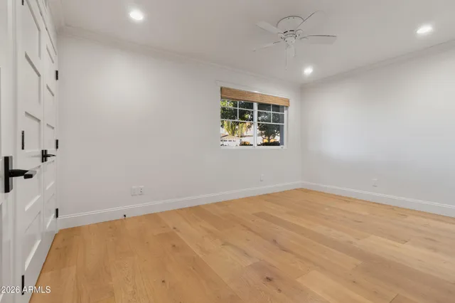 an empty room with a window and ceiling fan