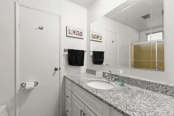 a bathroom with a granite countertop sink and a mirror