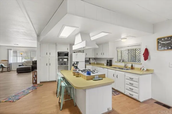 a kitchen that has a lot of cabinets in it and wooden floors