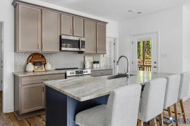 a kitchen with stainless steel appliances granite countertop a stove a sink a microwave and cabinets