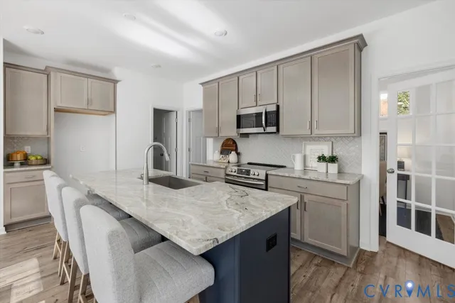 a kitchen with kitchen island granite countertop a sink stove and refrigerator