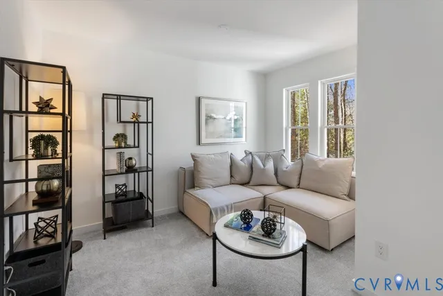 a living room with furniture a bookshelf and a window