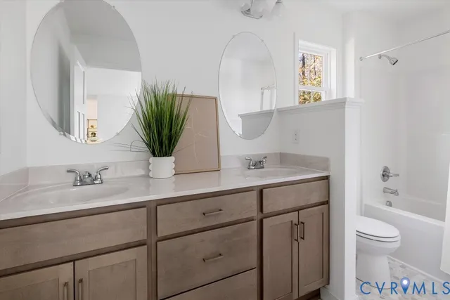 a bathroom with a granite countertop toilet sink and mirror