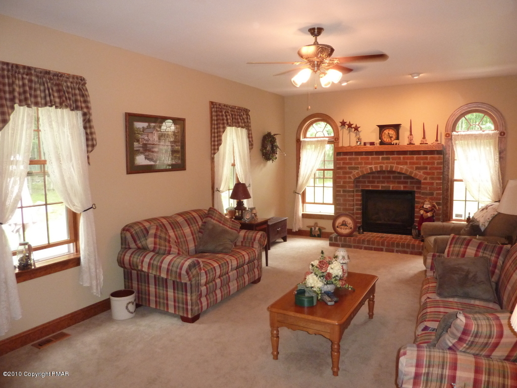 107 Fox Chase Road Stroudsburg, PA 18360 - Photo 3 of 28 a living room with furniture a fireplace and a chandelier