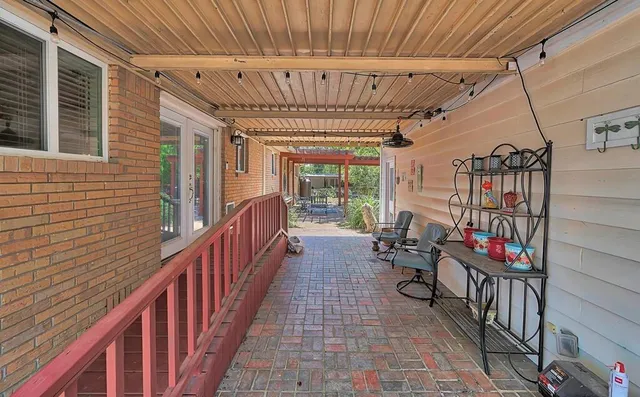 a view of a patio with table and chairs and potted plants with wooden floor and fence